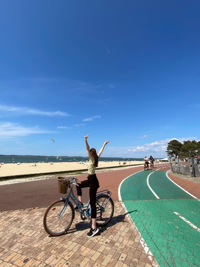natali on a bike in arcachon france in front of the popular sand beach