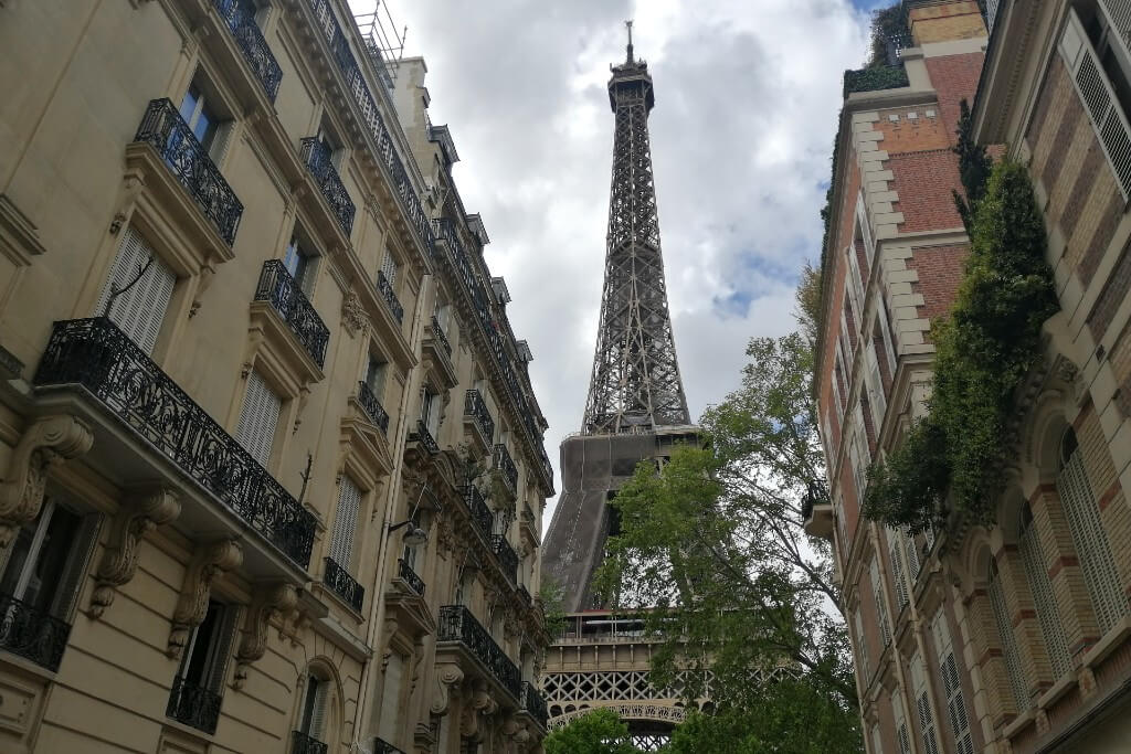 eiffel tower between the buildings at rue de universite