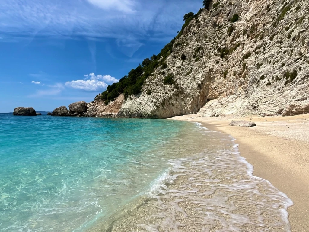 clear blue sea on a pebbled beach on a clear summer day