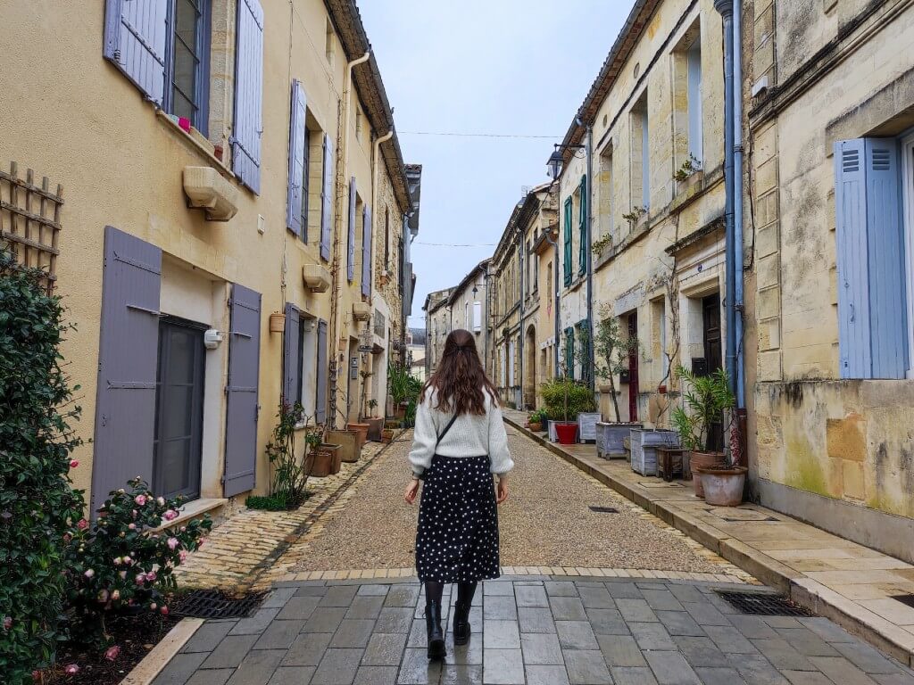 natali walking away from the camera in a village close to bodeaux in spring