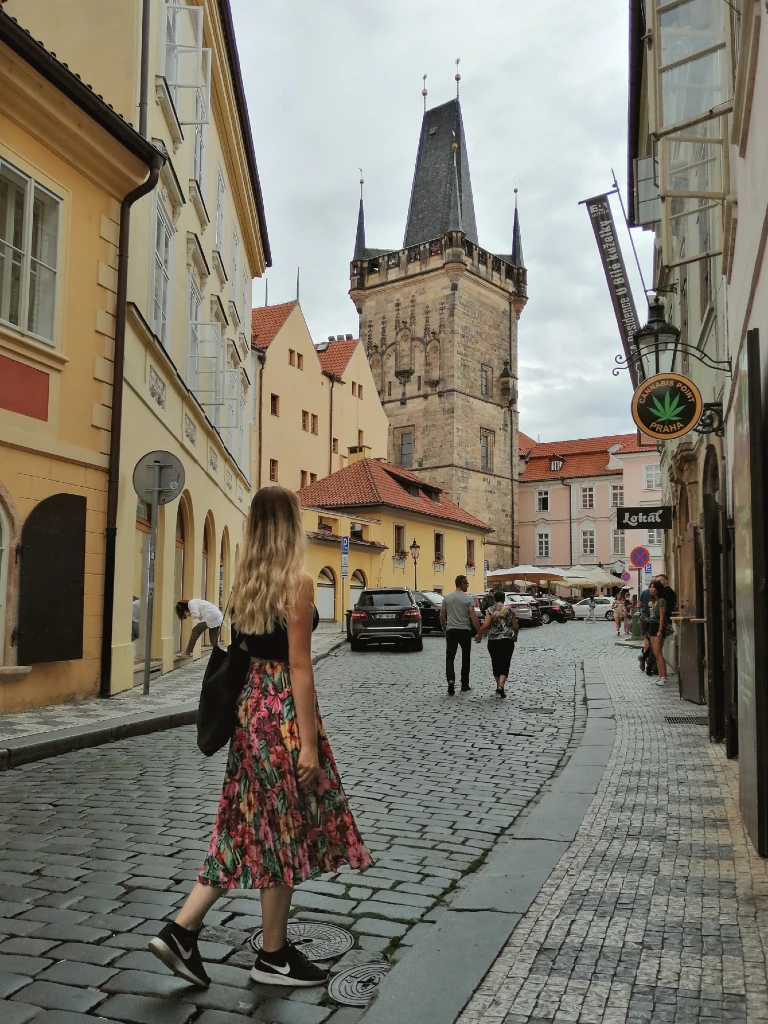 natali walking away from the camera on the cobblestone streets of prague old town