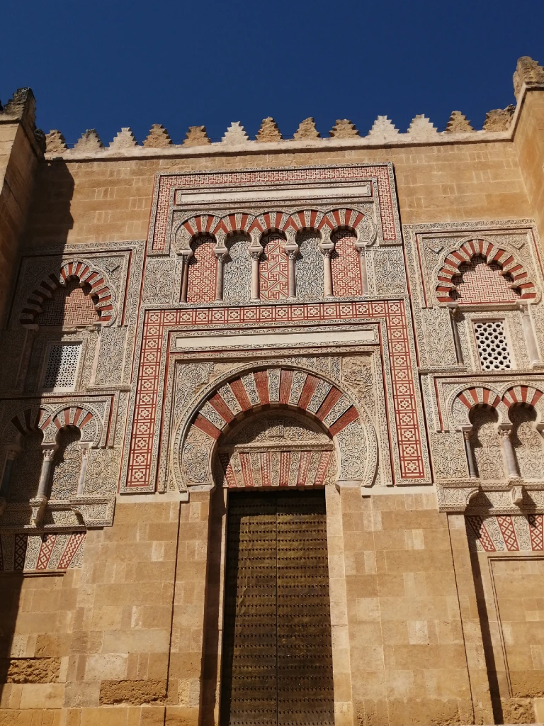colorful tiles surrounding a wooden door on the walls of mezquita in cordoba spain