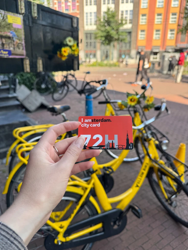amsterdam city card in front of yellow bike rental