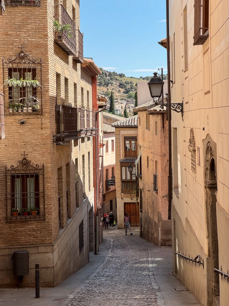 cobbled street lined with paste colored houses in toledo spain